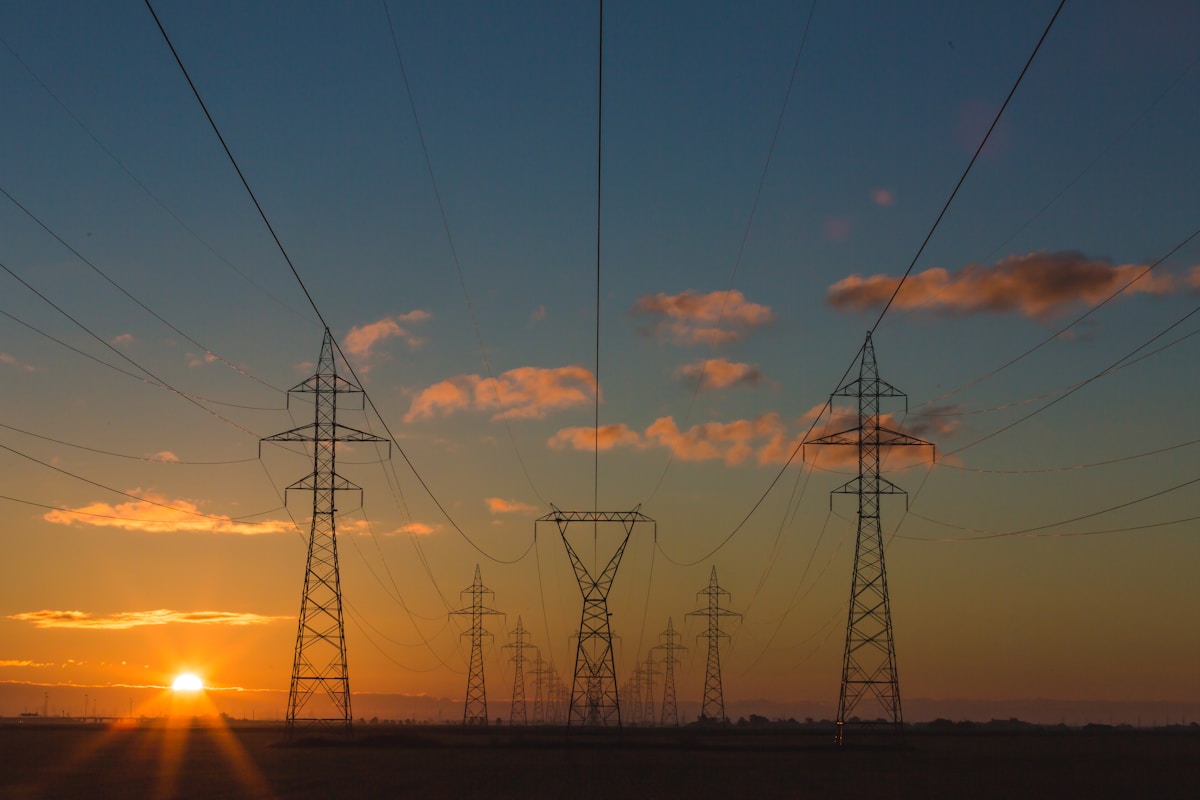 Electricity pylons at dusk representing power demand and grid infrastructure